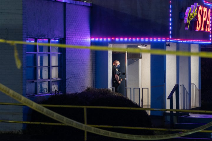 A police officer stands outside a massage parlor where three people were shot and killed on March 16, 2021, in Atlanta. The shooter killed a total of eight people that day, including Mario González's wife, Delaina Ashley Yaun.