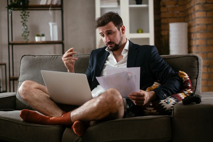 Businessman working online, wearing suit and no pants. Young man having video call. Businessman working at home.