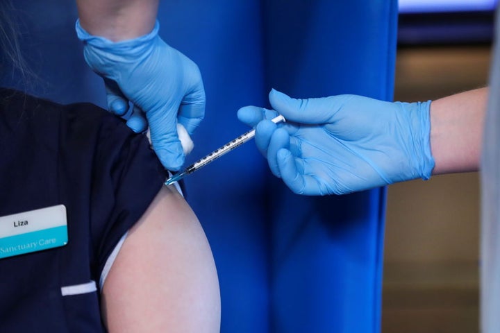 A member of staff receives the Pfizer/BioNTech COVID-19 vaccine at the Abercorn House care home in Scotland on December 14