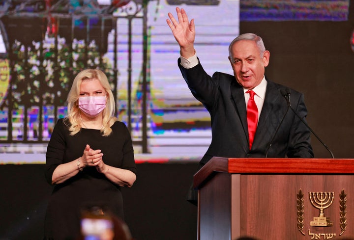 Israeli Prime Minister Benjamin Netanyahu, leader of the Likud party, appears with his wife Sara to address supporters at the party campaign headquarters in Jerusalem early on March 24, 2021, after the end of voting in the fourth national election in two years. (Photo by menahem kahana / AFP) (Photo by MENAHEM KAHANA/AFP via Getty Images)