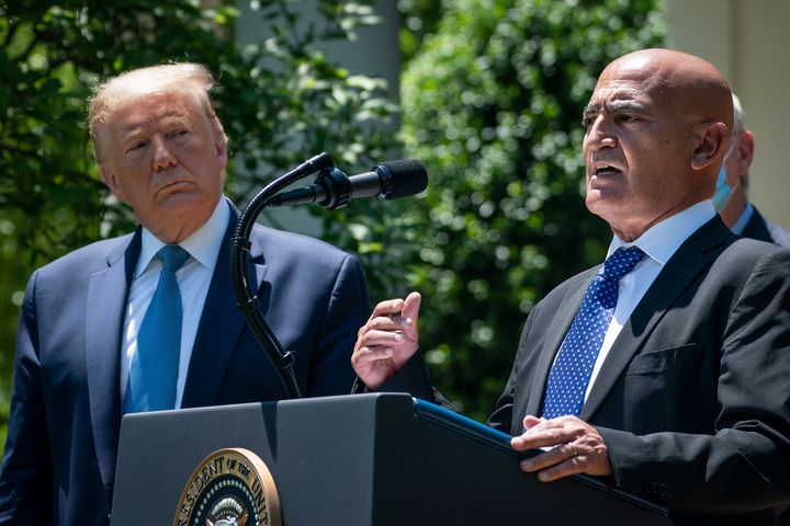 Then-President Donald Trump listens as Moncef Slaoui, the former head of GlaxoSmithKlines vaccines division, speaks about coronavirus vaccine development at the White House in May 2020.