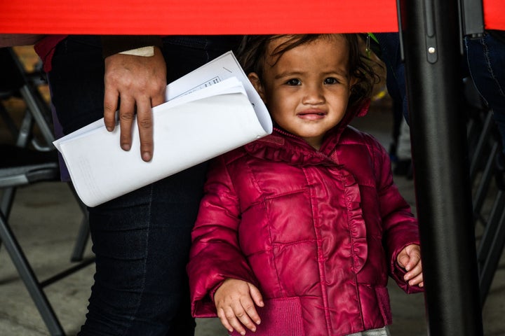 A migrant girl from Central America waits with her mother for a bus after they are dropped off by the U.S. Customs and Border Protection at a bus station near the Gateway International Bridge, between the cities of Brownsville, Texas, and Matamoros, Mexico, on March 15.