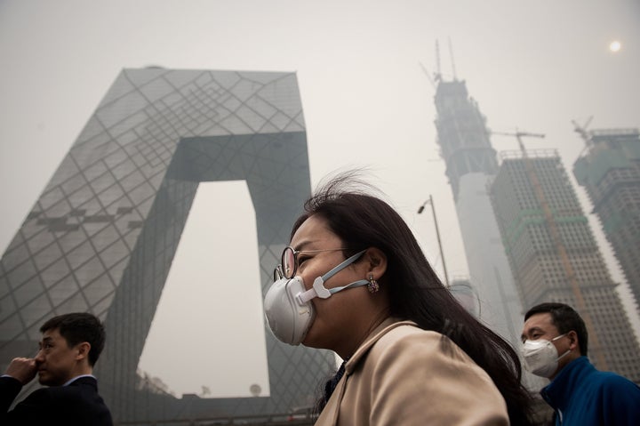 A woman wears a protective pollution mask on a street in Beijing, March 20, 2017.