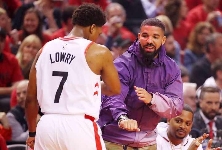 Drake fist-bumps Lowry during a playoff game in 2019.