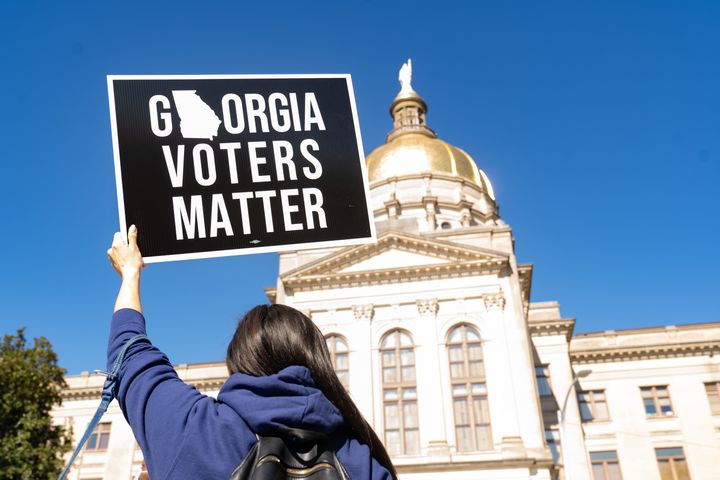 A demonstrator stands outside of the Georgia Capitol building in Atlanta on March 3, to oppose a measure that would dramatically limit access to voting throughout the state.