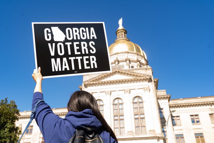 A demonstrator stands outside of the Georgia Capitol building in Atlanta on March 3, to oppose a measure that would dramatically limit access to voting throughout the state.