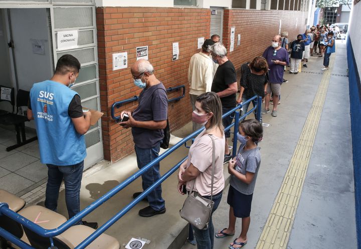 People stand in line to receive the coronavirus vaccine at a vaccination post at the Santa Cecilia Basic Health Unit on March 15 in São Paulo.