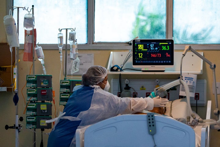 A health worker tends to a patient at the intensive care unit for patients infected with COVID-19 at the reference hospital Ronaldo Gazolla on March 24 in Rio de Janeiro, Brazil.