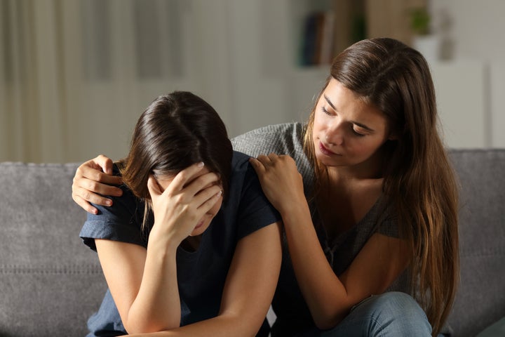 Una chica reconforta a otra que está llorando.