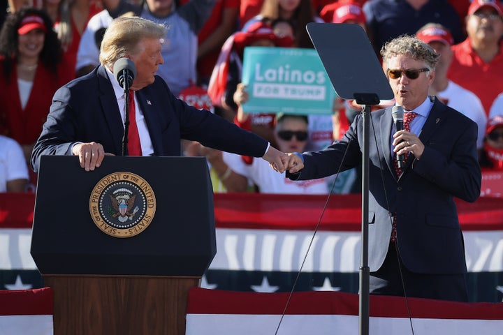 Sen. Rand Paul, right, gives a fist bump to then-President Donald Trump while praising the president during a campaign rally