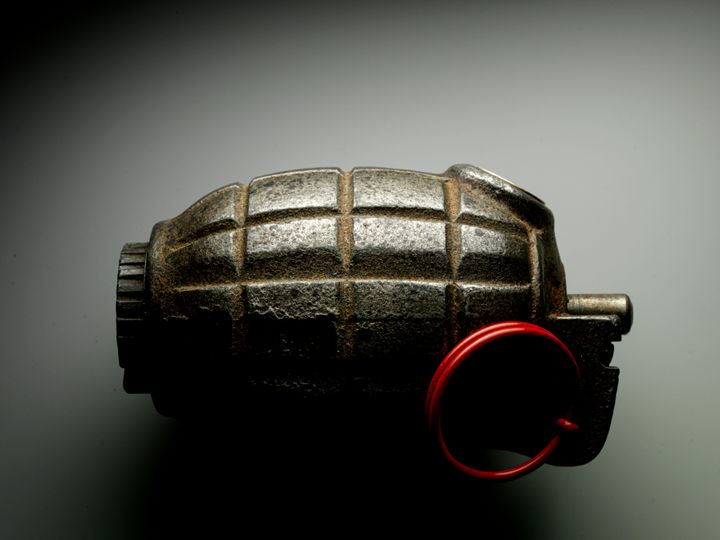 Close up hand grenade against gray background