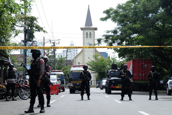 MAKASSAR, INDONESIA - MARCH 28: Police officers stand guard in the front of the Sacred Heart of Jesus Cathedral after a suici