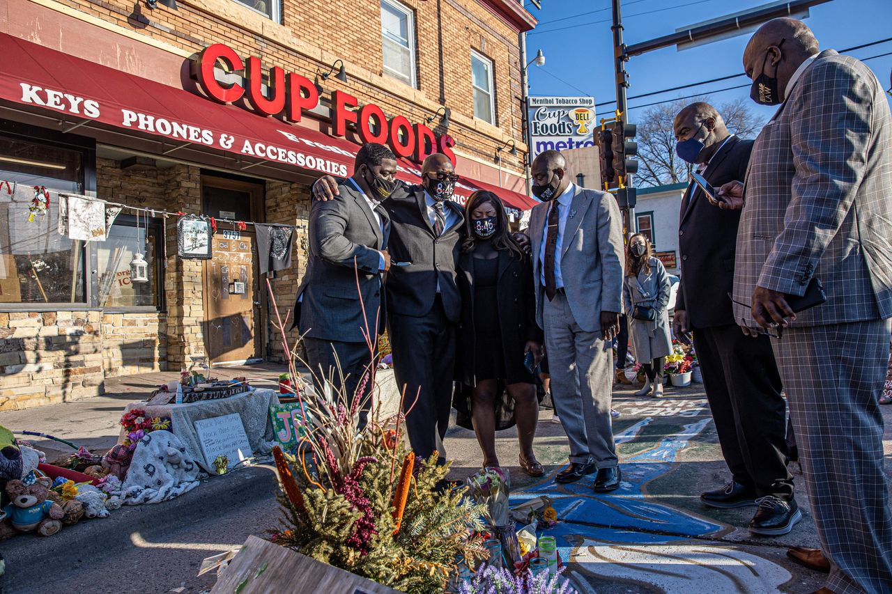 George Floyd's family, including brother Philonise Floyd (2nd L), and Floyd family lawyer Ben Crump (R) visit a memorial on March 12 at the site where George Floyd died in Minneapolis.