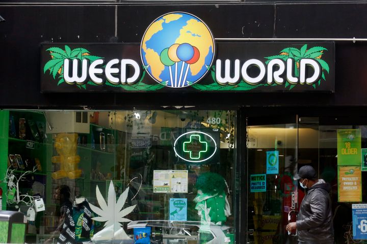 A man opens the door of the Weed World Store in New York City on Thursday. New York State has reached a deal to legalize recr