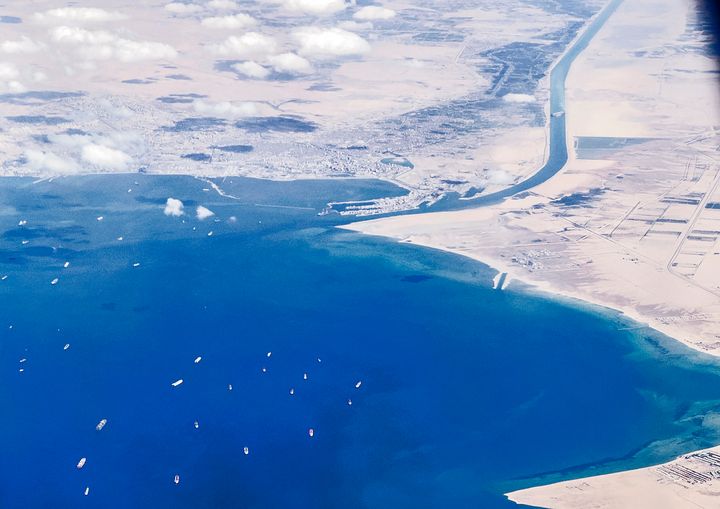 An aerial view taken on March 27, 2021 from the porthole of a commercial plane shows stranded ships waiting in line in the Gulf of Suez to cross the Suez Canal at its southern entrance.