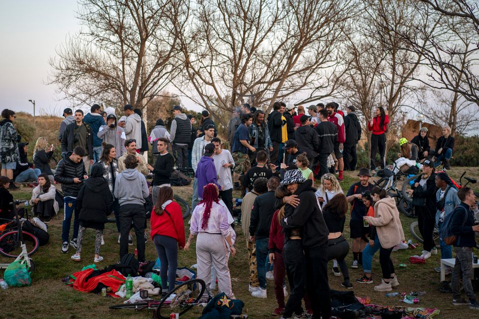 Un grupo de personas, reunidas sin distancia ni mascarillas en un parque de