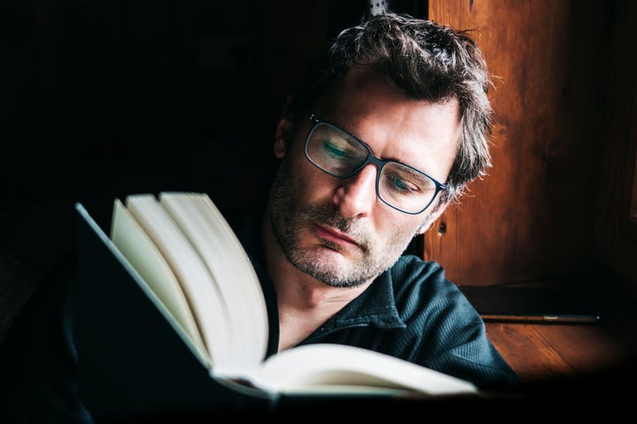 Una hombre leyendo un libro.