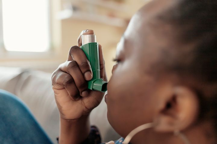 African American Woman Having Asthma Using the Asthma Inhaler for Being Healthy