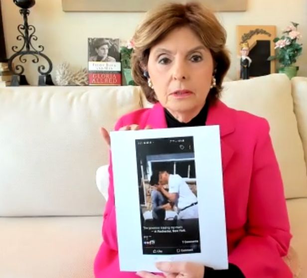 Gloria Allred displaying a photo of Gov. Andrew Cuomo (D) kissing Sherry Vill.