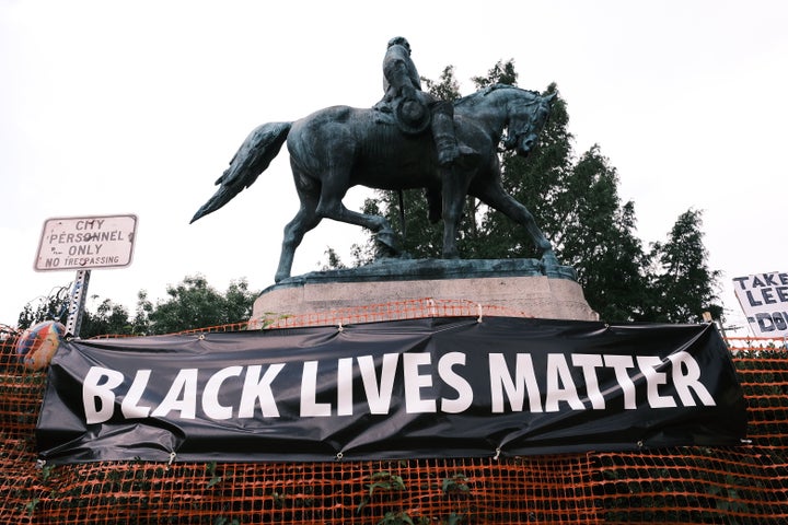 A "Black Lives Matter" banner hangs before a Robert E. Lee statue in Charlottesville, Virginia. McAuliffe backed the removal of Confederate statues in 2017. In 2015, he supported keeping them.