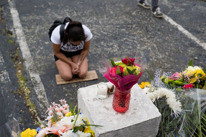 Flowers and signs adorn Gold Spa in Atlanta, where people protested violence against women and Asians following the shootings that took eight lives.