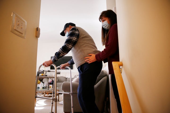 A home health care aide steadies her client inside his home in Peabody, Massachusetts on Jan. 25, 2021. Ever since the 2020 p