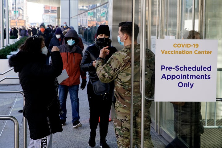 There are financial and psychological costs to getting a COVID-19 vaccine that employers can make easier — or harder — for their workers. Above, people wait to enter the Javits Center in New York City to receive a vaccine in March.