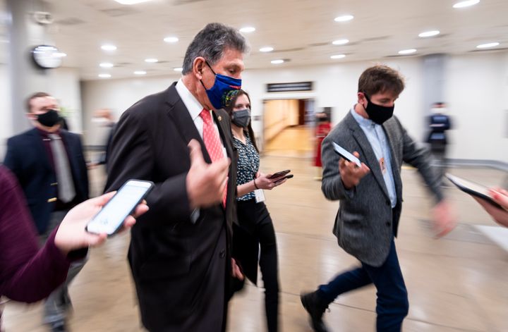Sen. Joe Manchin (D-W.Va.) speaks with reporters in the Senate subway as he arrives for a vote in the Capitol on Wednesday, March 24.