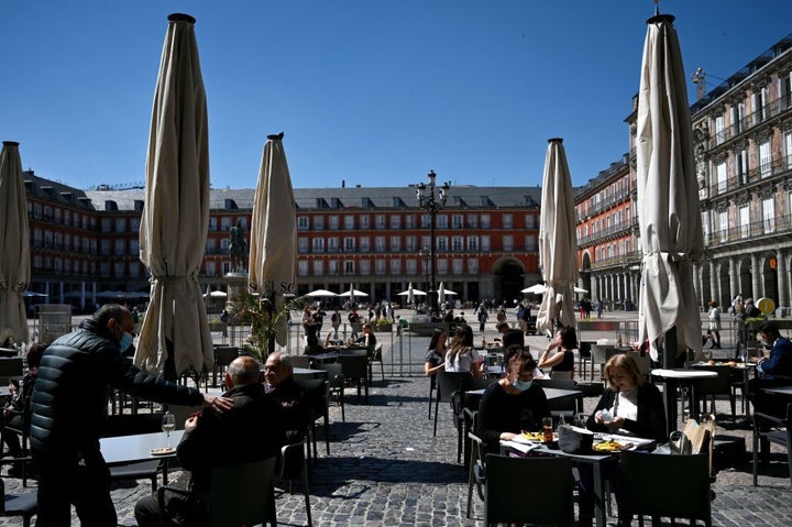 Un grupo de ciudadanos y turistas sentados en una terraza en la plaza Mayor de Madrid.