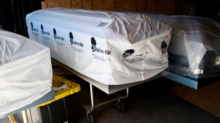 Covered empty caskets stand in a garage at Boyd Funeral Home on Jan. 14, 2021, in Los Angeles.