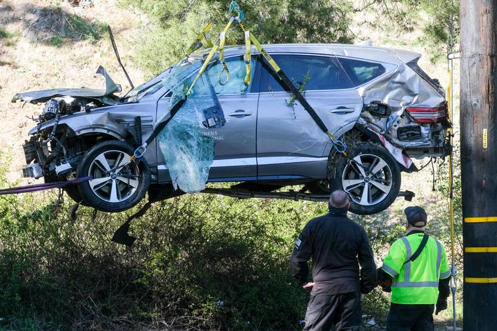 In this Feb. 23, 2021, file photo, a crane is used to lift a vehicle following a rollover accident involving golfer Tiger Woods, in the Rancho Palos Verdes suburb of Los Angeles. Authorities said Wednesday, April 7, Woods was speeding when he crashed leaving him seriously injured. (AP Photo/Ringo H.W. Chiu, File)