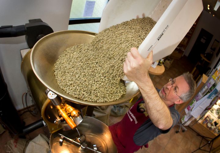 Green coffee beans (actually seeds) are poured into a roaster at Hansen Coffee Rosters in Roedermark, Germany.