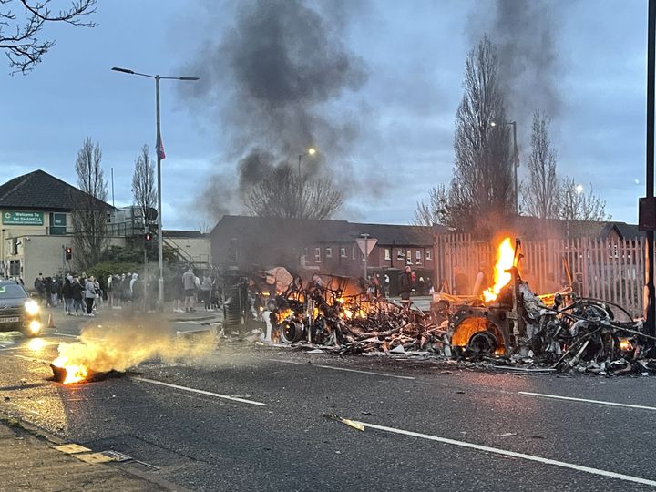 The wreckage of a Translink Metrobus on fire on the Shankill Road in Belfast during further unrest.