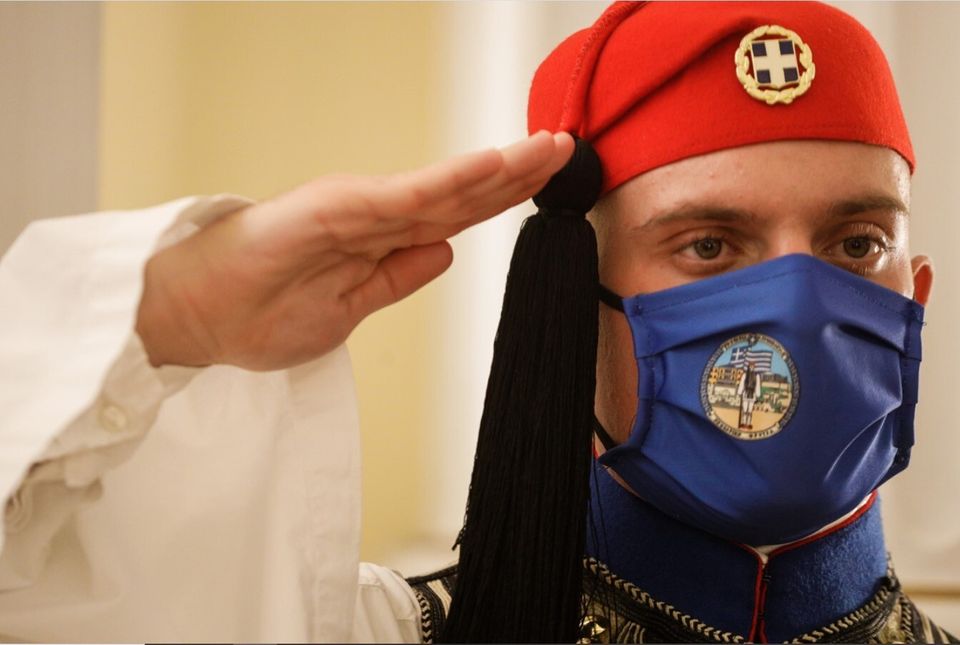 Εύζωνας, μέλος της προεδρικής φρουράς, χαιρετάει στρατιωτικά φορώντας μάσκα για προστασία από τον COVID-19....