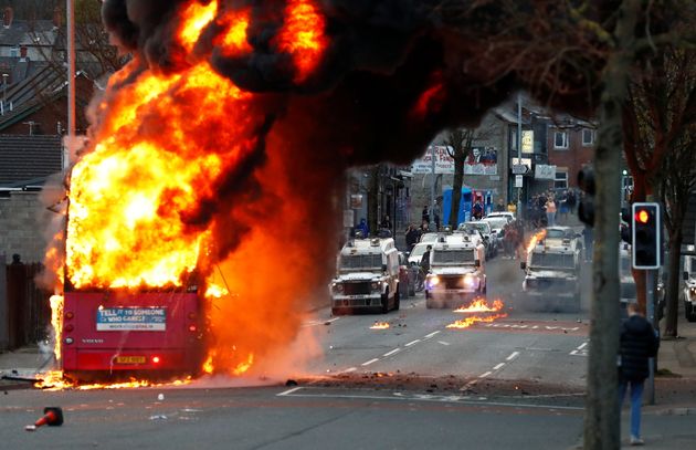 Des véhicules de police devant un bus en feu à Belfast, en Irlande du Nord, le 7 avril 2021.