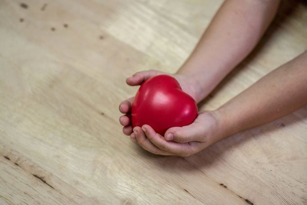 Child's hands with a red heart