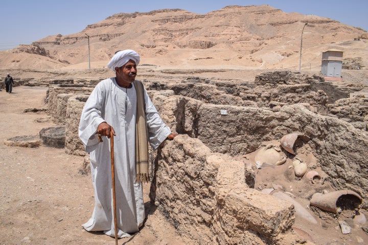 Aly Farouk, trabajador jefe de la excavación, de pie junto a los restos de la "ciudad perdida" de Luxor, una urbe de 3.000 años de antigüedad que esconde una fascinante historia.