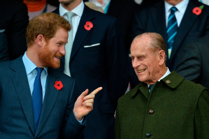 Prince Harry speaks with his grandfather Prince Philip as they watch the final match of the 2015 Rugby World Cup on Oct. 31, 2015.