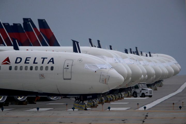 In this May 14, 2020 file photo, several dozen mothballed Delta Air Lines jets are parked on a closed runway at Kansas City International Airport in Kansas City, Mo. (AP Photo/Charlie Riedel, File)