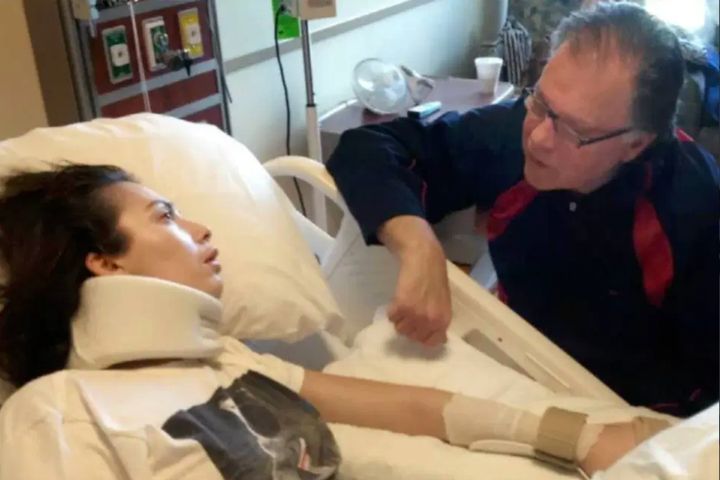 In this undated photo, Chantel Giacalone (left) lies in a hospital bed after suffering brain damage from an allergic reaction. On the right, her father, Jack Giacalone, speaks to her.