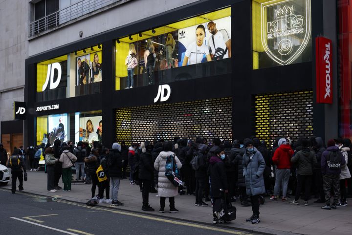 People queue outside a JD Sports shop on Oxford Street as retail reopens after coronavirus restrictions ease in London.