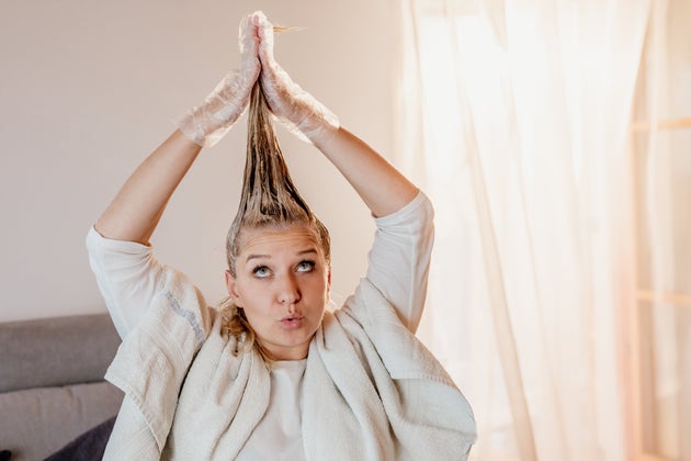 Woman having fun dyeing her hair at home