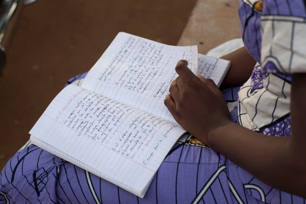 Μαθήτρια σε σχολείο στη Νιαμέι, διαβάζει από το τετράδιό της. 