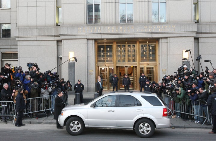 Madoff's vehicle is seen surrounded by members of the press as he arrives at the Manhattan Federal court on March 12, 2009, in New York City where he pled guilty to all 11 felony charges brought by prosecutors.