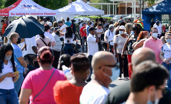 People wait in line for hours on April 9, 2021, at a pop-up COVID-19 vaccination site in the parking lot of Bravo Supermarket in a predominantly Black and Hispanic neighborhood in Orlando. The one-day mobile site offered 400 doses of the popular one-shot Johnson and Johnson vaccine. 