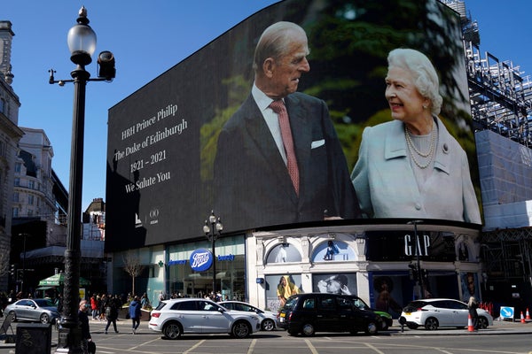 Images of the queen and the duke are displayed on screens at Piccadilly Circus in London while the funeral is held at Windsor