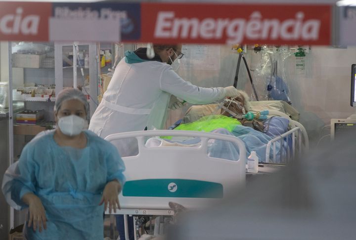 Les agents de santé traitent un patient COVID-19 à l'unité d'urgence d'un hôpital de campagne mis en place pour traiter les patients COVID à Ribeirao 