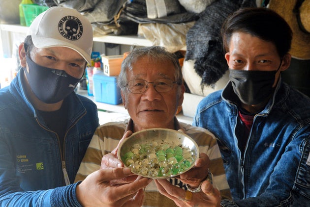 謎の球体を見つけた山本秀行さん(中央)ら=2021年4月17日午後3時35分、山口県光市三輪、垣花昌弘撮影