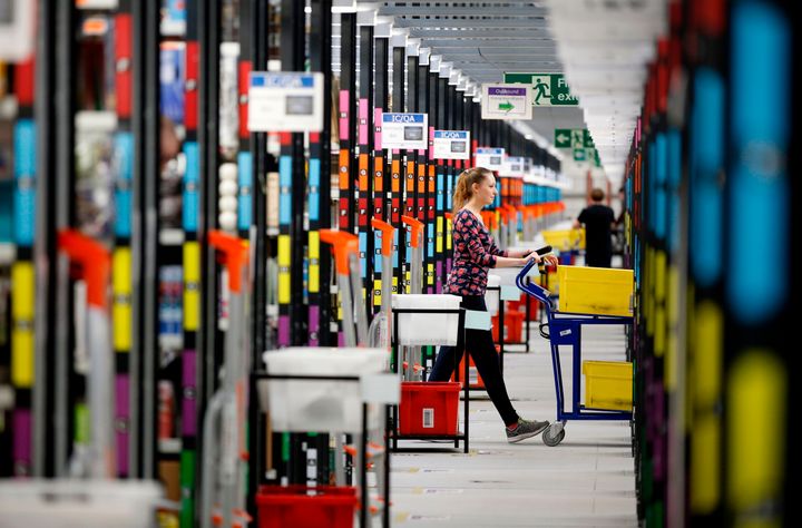 A 'picker' worker collects items from storage shelves as she collates a customer order inside an Amazon.co.uk fulfillment centre in Hemel Hempstead, north of London, in 2015