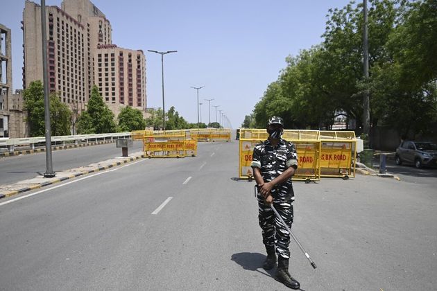 Un policier monte la garde devant un checkpoint pendant le couvre feu imposé par le gouvernement en raison de l'augmentation du nombre de cas de Covid-19 à New Delhi le 18 avril 2021